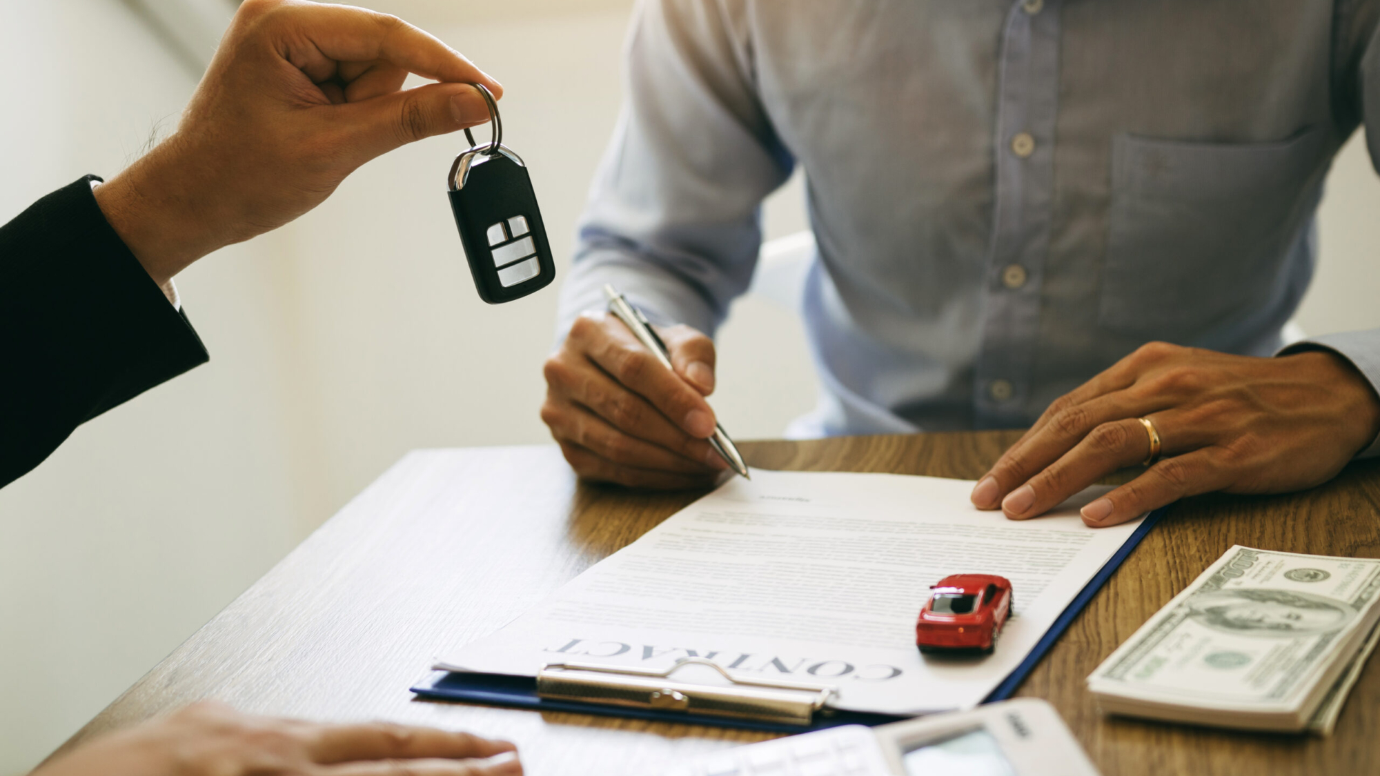 New car buyers sign contract documents for new car purchases at the showroom, the salesperson's office.